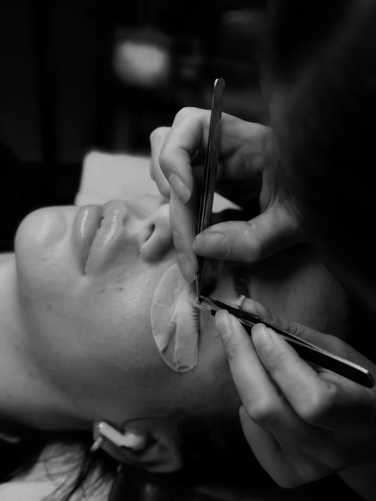 Applying lash extensions with tweezers in the studio